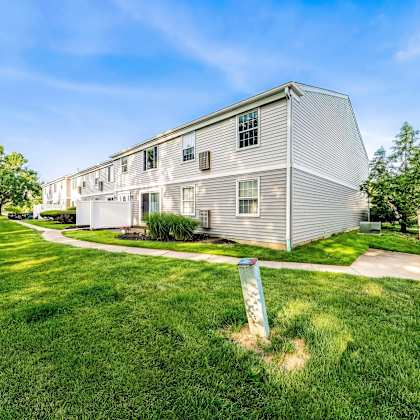 a residential building with a well-maintained lawn in front.
