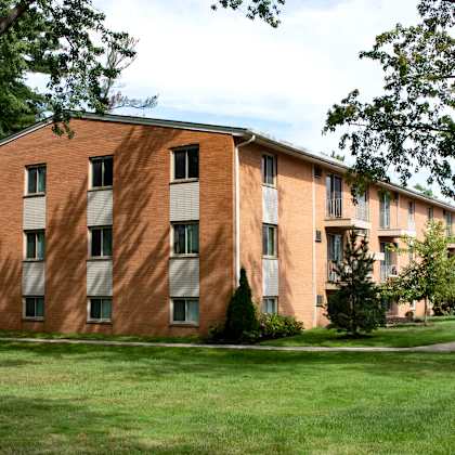 a large brick building with a green lawn in front. at integrity berea apartments, berea, oh, 44017