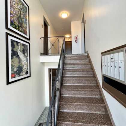 a stairway with a metal railing and pictures on the wall