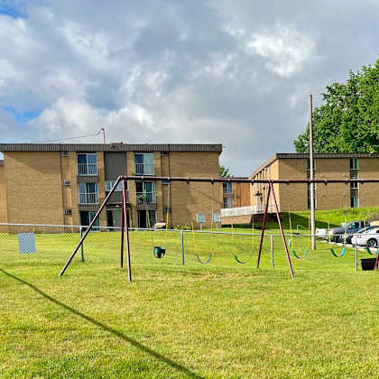 a swing set in front of an apartment building