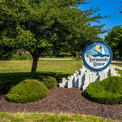 a sign for the northwest manor mall in front of a tree