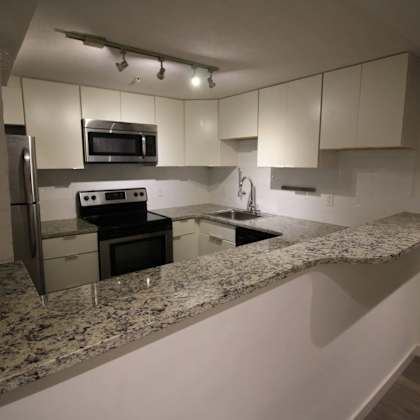 a kitchen with granite countertops and stainless steel appliances.