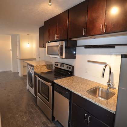 a kitchen with dark wood cabinets and stainless steel appliances.