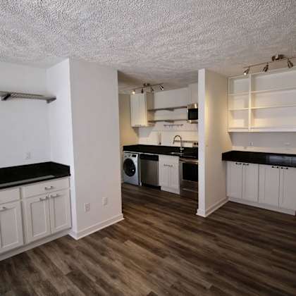 a kitchen with white cabinets and a black countertop.