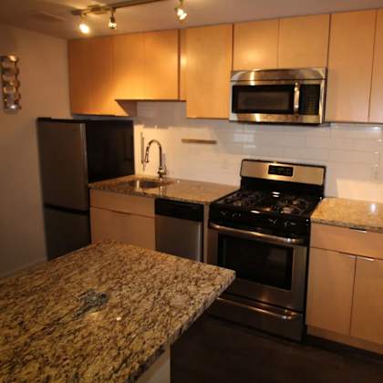 a kitchen with granite countertops and stainless steel appliances.