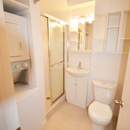 a white bathroom with a toilet and a shower