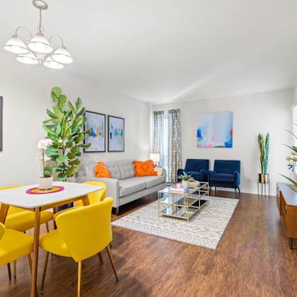 a living room with a white table and yellow chairs.