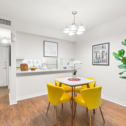 a room with a white table and yellow chairs.