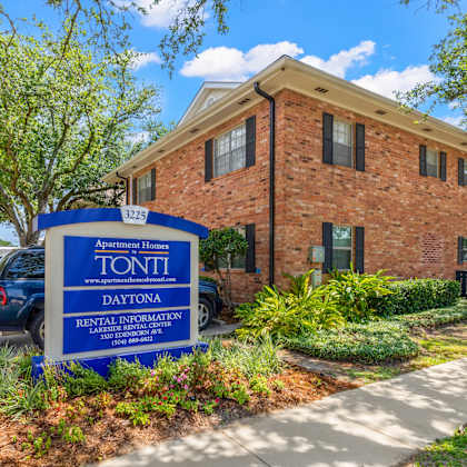 a brick building with a sign that says apartment homes tonti daytona rental information center.