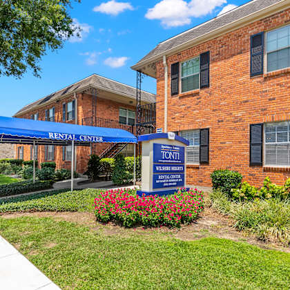 a rental center sign is displayed in front of a brick building.