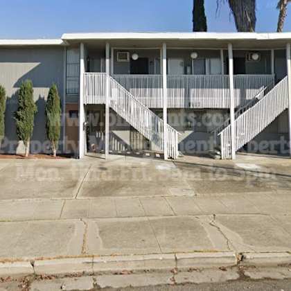 a house with a porch and stairs on a street