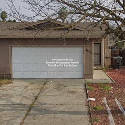a house with a garage door that has a sign on it.