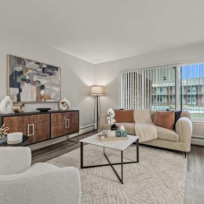 a modern living room with a white sofa, a coffee table, and a large painting on the wall.