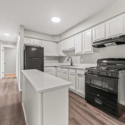 a kitchen with white cabinets and black appliances