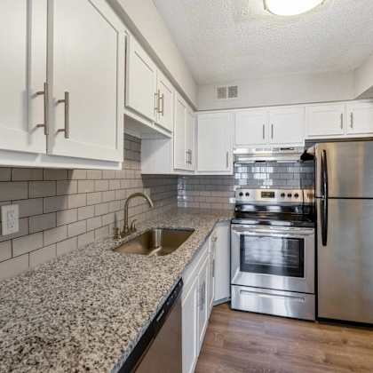 a kitchen with a stainless steel refrigerator, oven, and sink.