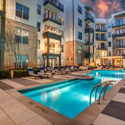 a large swimming pool in the middle of a courtyard surrounded by buildings.