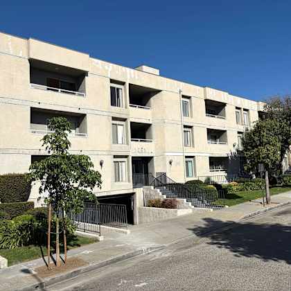 a street view of a residential building with a clear blue sky.