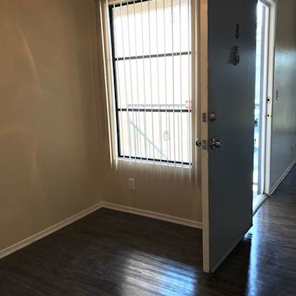 an empty room with a large window and a door