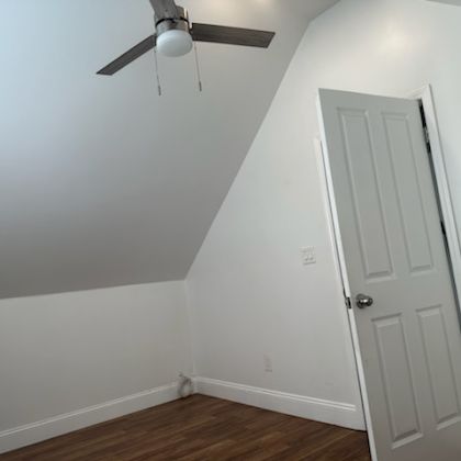 a bedroom with a white door and a ceiling fan