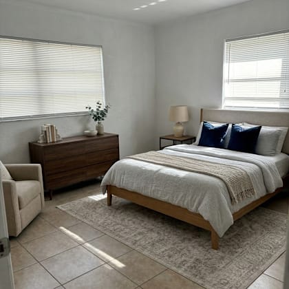 a bedroom with a bed, chair, and nightstand.