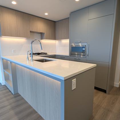 a modern kitchen with a white countertop and stainless steel appliances.