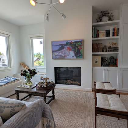 a living room with a fireplace and a painting on the wall.
