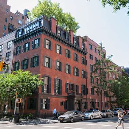 a red brick building with green shutters on the windows.