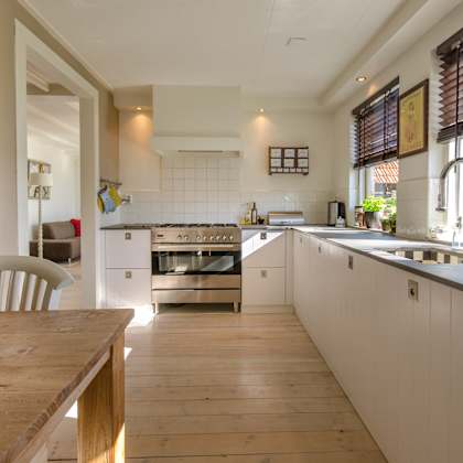 a modern kitchen with a wooden table and white cabinets.