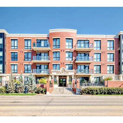 a large red brick apartment building with a balcony on the second floor.