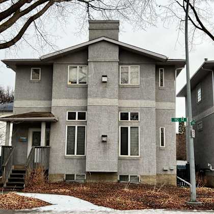 a grey house with a white door and windows.