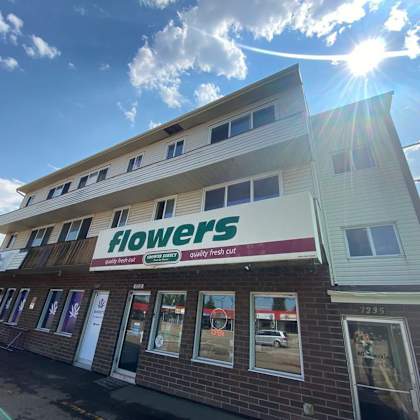 a flower shop with a sign that says "flowers" on the front.