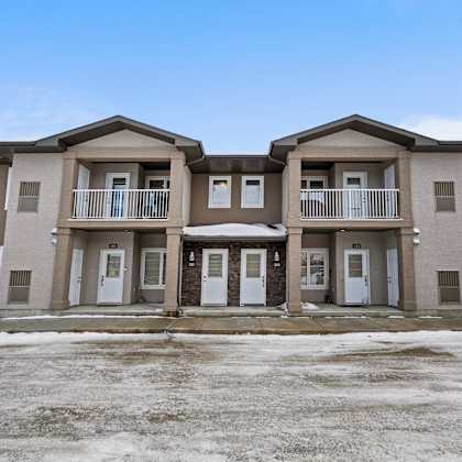 a row of three houses with brown and beige exteriors.