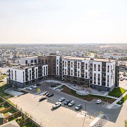 a large white building with a parking lot in front of it at vista apartments at edgemont, edmonton, ab