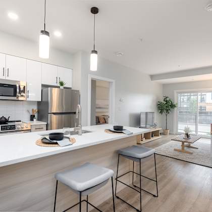 a modern kitchen with a stainless steel refrigerator and a white countertop.