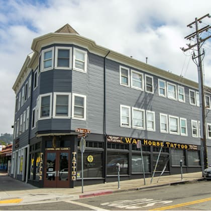 a street view of a building with the sign "war horse tattoo" on it.