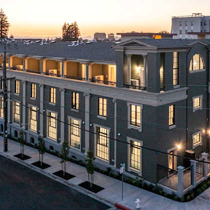 a large, well-lit building with a balcony on the second floor.