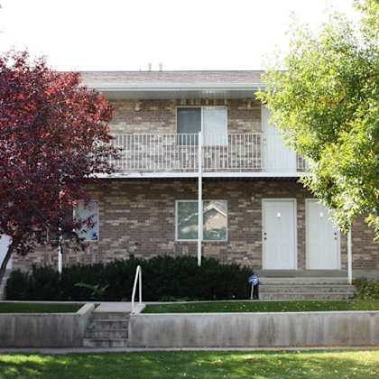 a house with a white door and a tree in front.