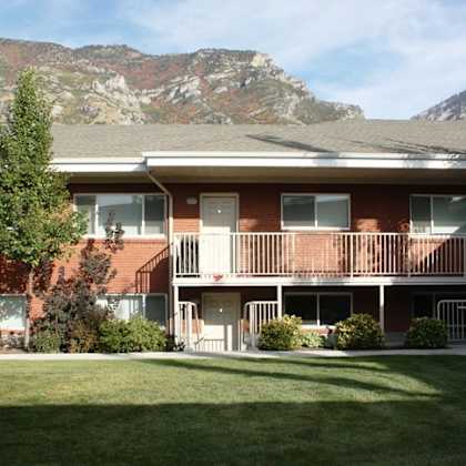 a red brick building with a mountain in the background.