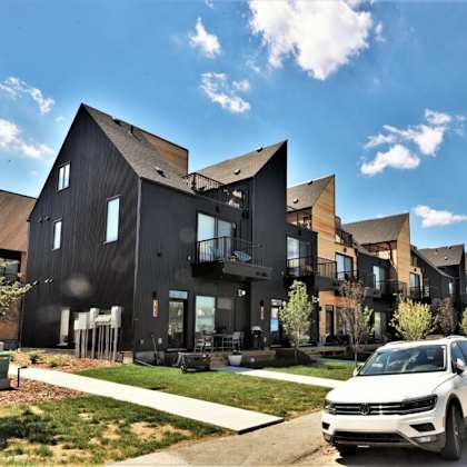 a row of houses with cars parked in front of them