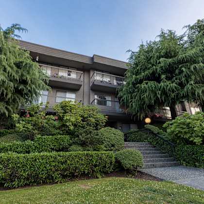 an apartment building with trees in front of it