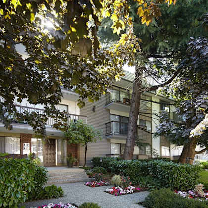 a picture of an apartment building with a garden in front of it