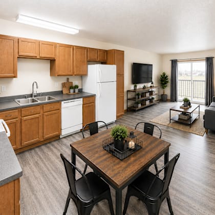 a kitchen with a dining table and chairs in the foreground.