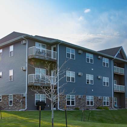 a large apartment building with a grassy area in front.