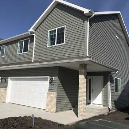 a grey house with a white garage door.