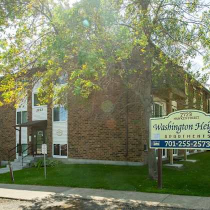 a sign for washington heights apartments is in front of a brick building.