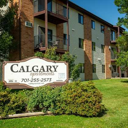 a calgary apartments sign in front of a building.
