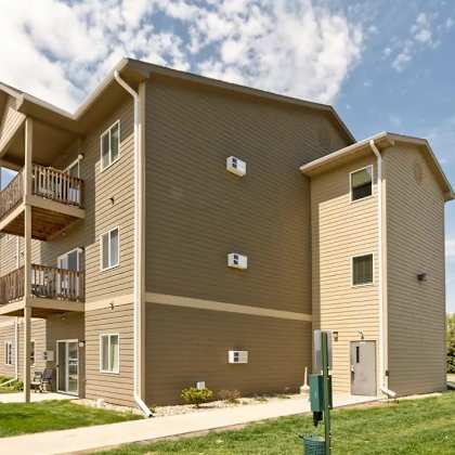 a large apartment building with multiple balconies and doors.
