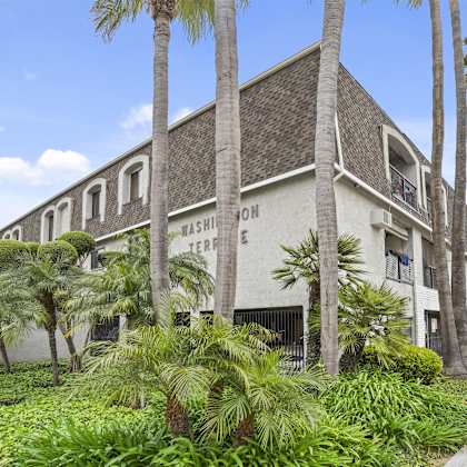 a building with the words "washington terrace" on it is surrounded by palm trees.