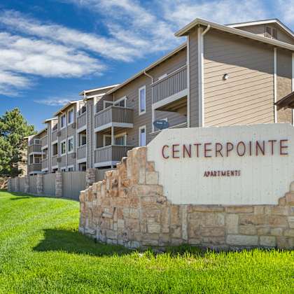 a stone sign that says centerpointe apartment in front of a building.