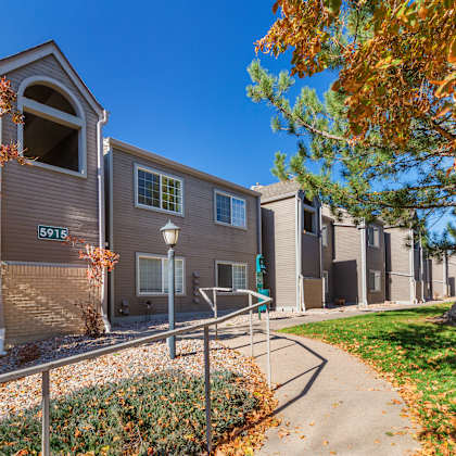 a building with the number 5915 on it is surrounded by trees with orange leaves.